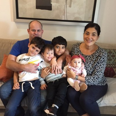 The Holohan family sitting on a couch, with four children on their parents' laps